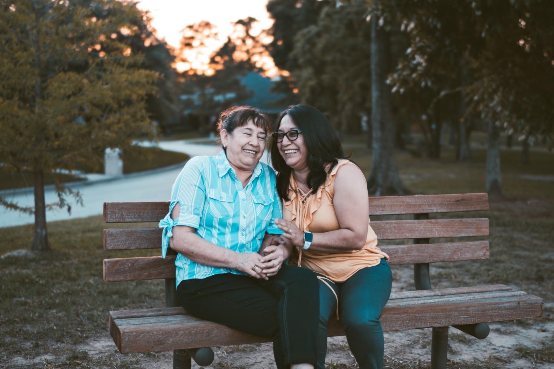 Woman and her mother sitting on a park bench