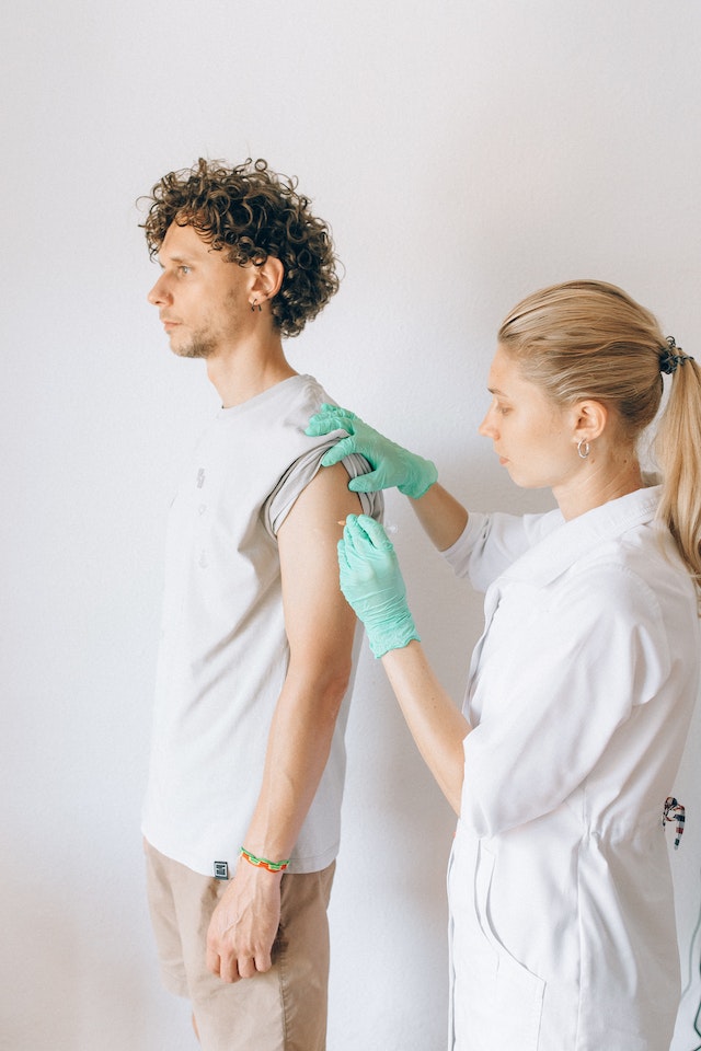 doctor giving her patient a vaccine