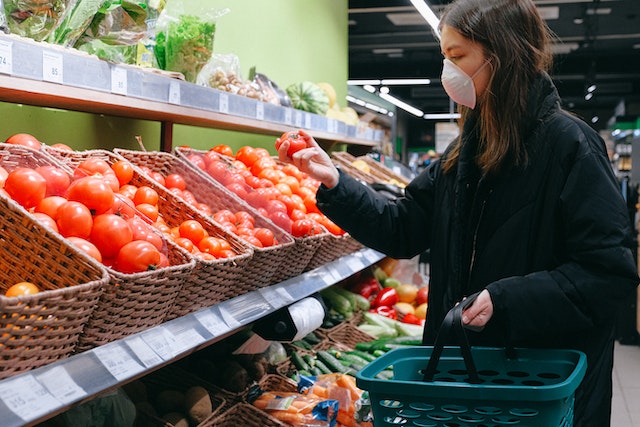 Woman looking at tomatoes at the grocery store