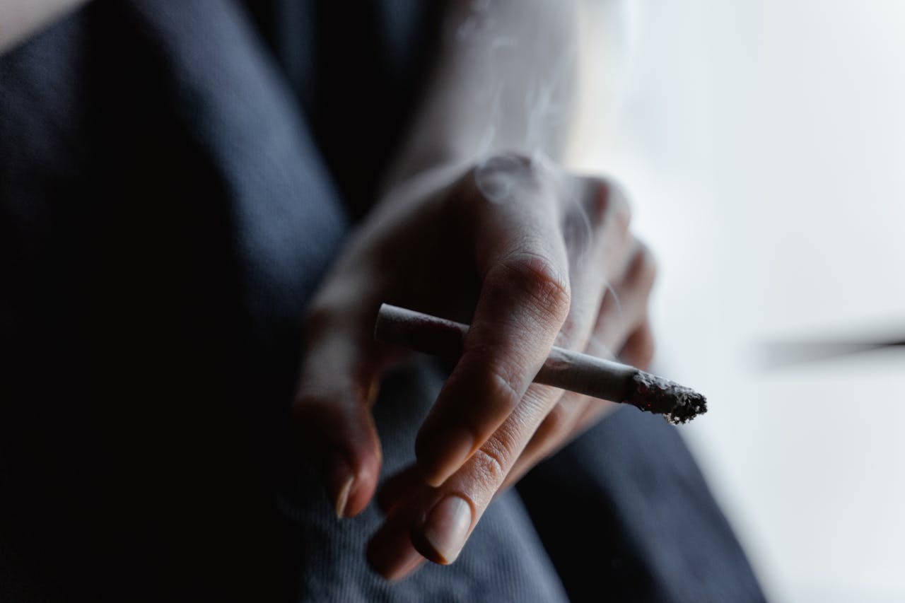 Hand holding a lit cigarette