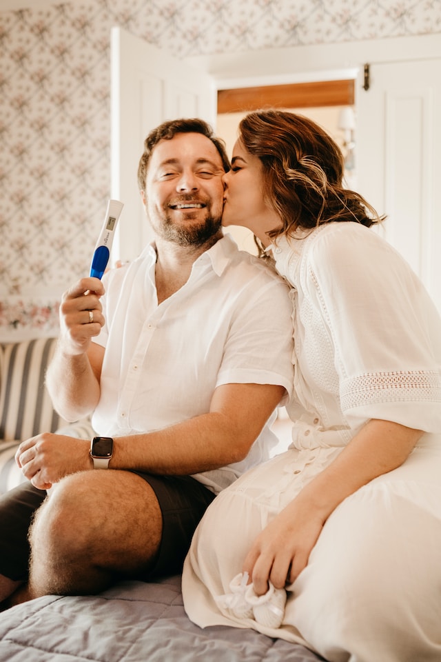 husband and wife holding up home pregnancy test