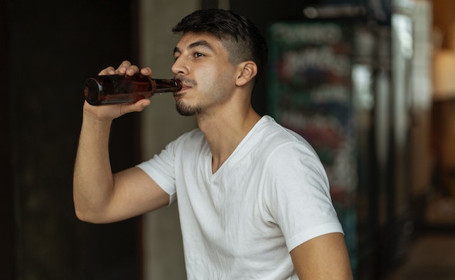 man drinking beer from a bottle