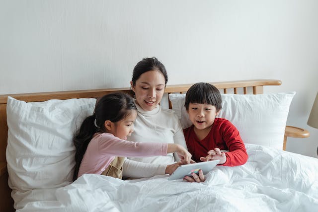 Mom laying in bed with her children