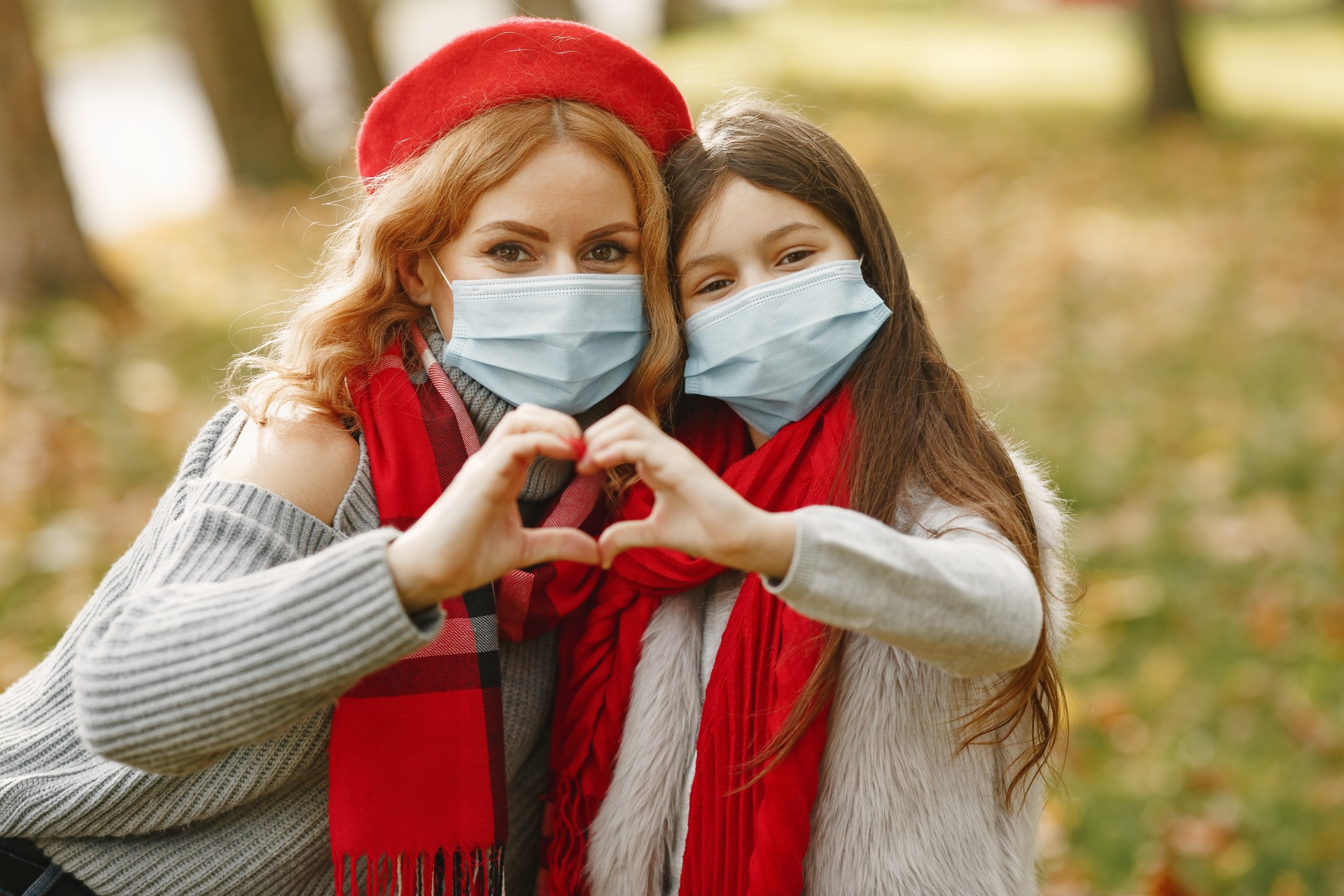 woman and girl forming a heart symbol with their hands