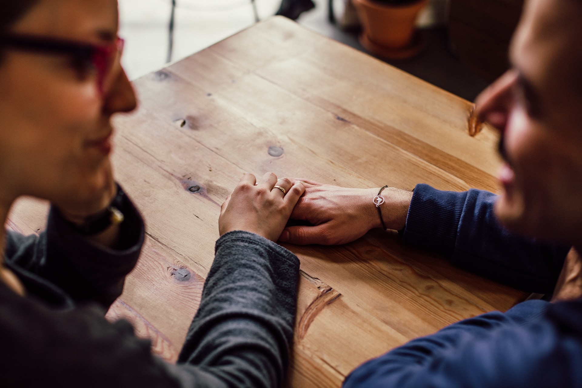 Man and woman sitting together, touching hands