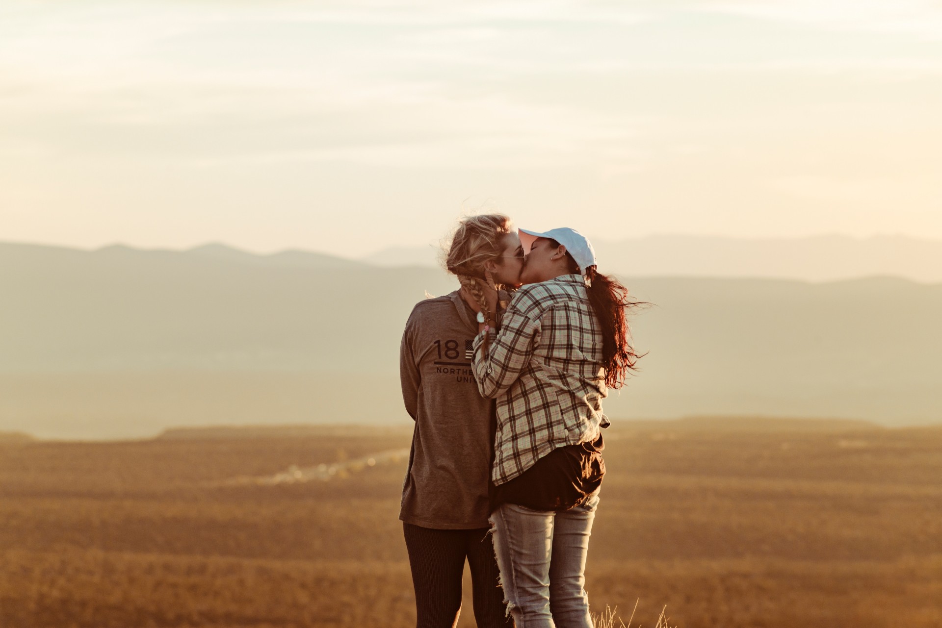 Two women kissing in a field