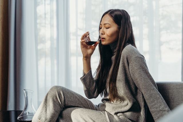 woman drinking a glass of alcohol