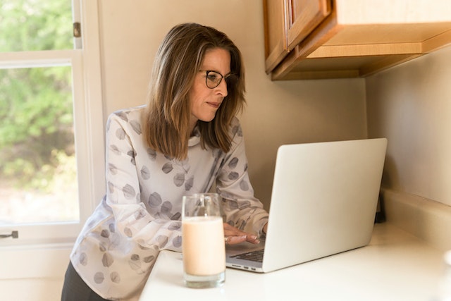 Woman drinking milk at her laptop