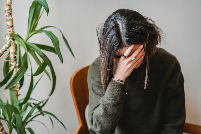 woman with adrenal fatigue rubbing her face